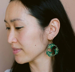 Side profile of a woman wearing Denz Wattle Wreath Earrings in Black/Green/Yellow 