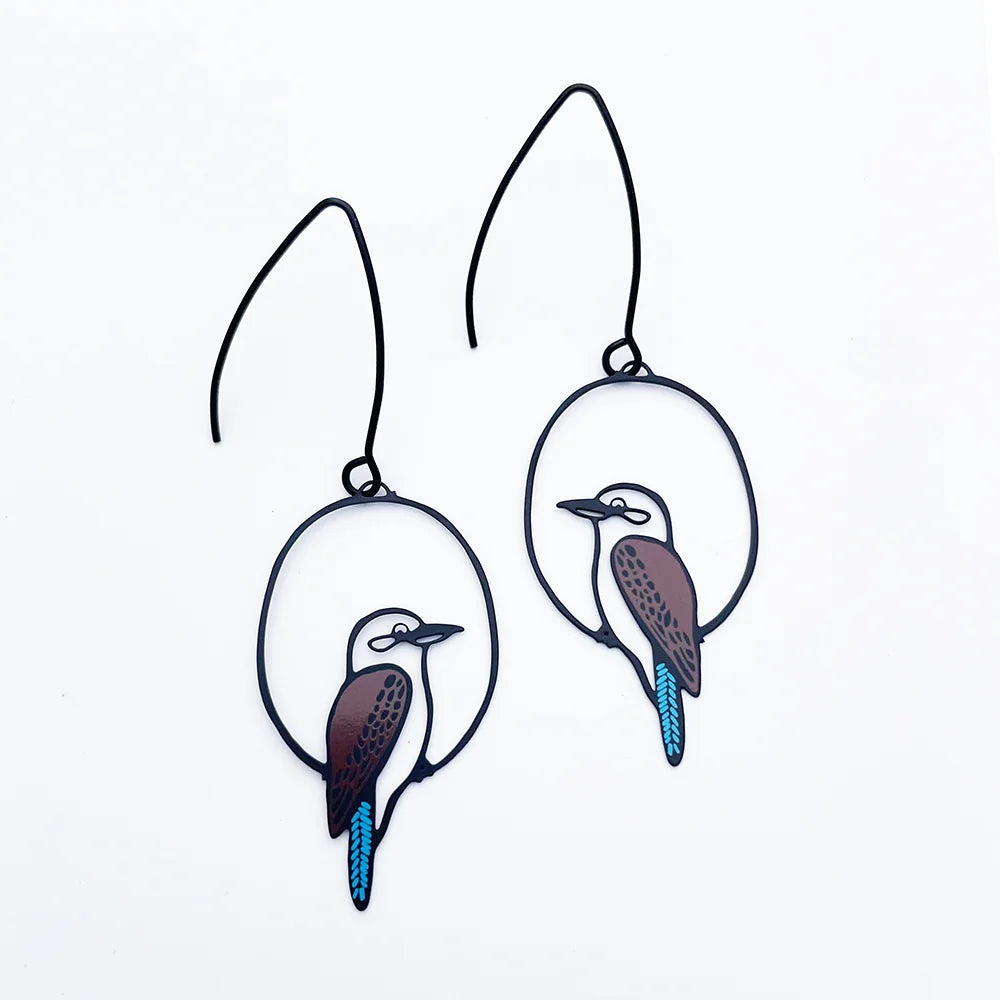 A pair of DENZ black metal wire hoop earrings featuring cutout kookaburra bird designs with brown, white, and bright blue accents, displayed on a clean white background.
