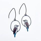 A pair of DENZ black metal wire hoop earrings featuring cutout kookaburra bird designs with brown, white, and bright blue accents, displayed on a clean white background.
