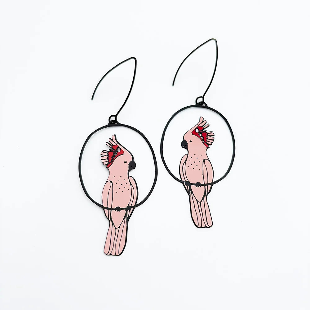 A pair of DENZ Pink Cockatoo  earrings featuring a red crest details, shown against a plain white background.
