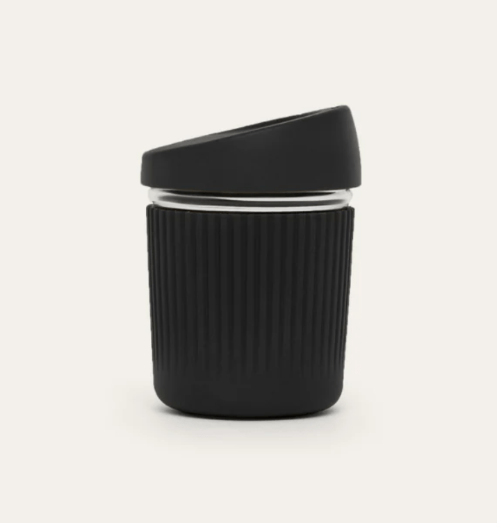 Seed & Sprout 8oz reusable glass coffee cup in Liquorice featuring a protective LFGB silicone sleeve and matching slanted lid.