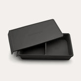 An open Seed & Sprout 2 Portion Silicone Freezer Tray in Liquorice with two partitioned sections and its matching embossed lid resting partially on top.