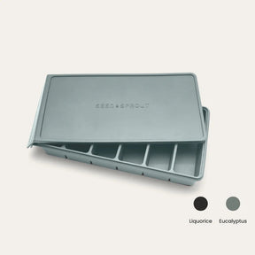 An open Eucalyptus Seed & Sprout 6-portion silicone freezer tray with its matching embossed lid resting partially on top, accompanied by color swatch indicators for Liquorice and Eucalyptus.