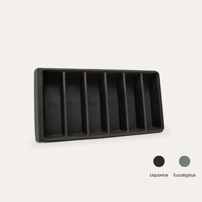 An Seed & Sprout 6-portion silicone freezer tray with six empty compartments, accompanied by color swatches for Liquorice and Eucalyptus.   