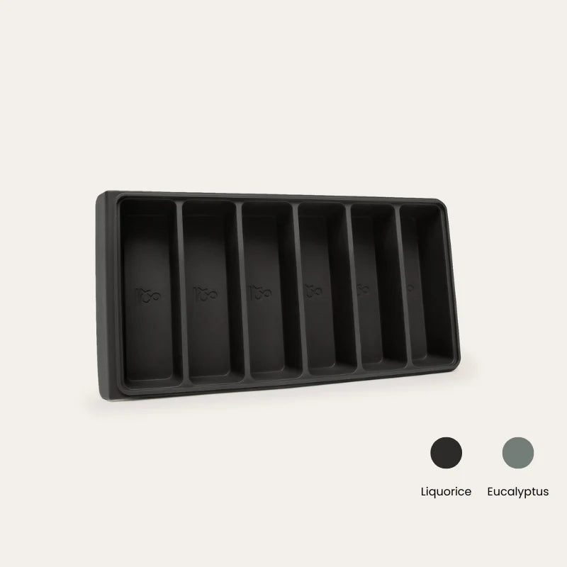 An Seed & Sprout 6-portion silicone freezer tray with six empty compartments, accompanied by color swatches for Liquorice and Eucalyptus.   