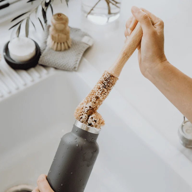 Seed & Sprout Beechwood Bottle Cleaning Brush washing a stainless steel drink bottle.