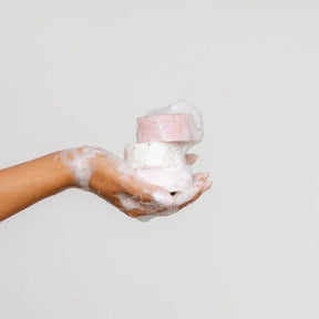 Seed & Sprout eco-friendly solid soap bars lathered in a soapy hand.