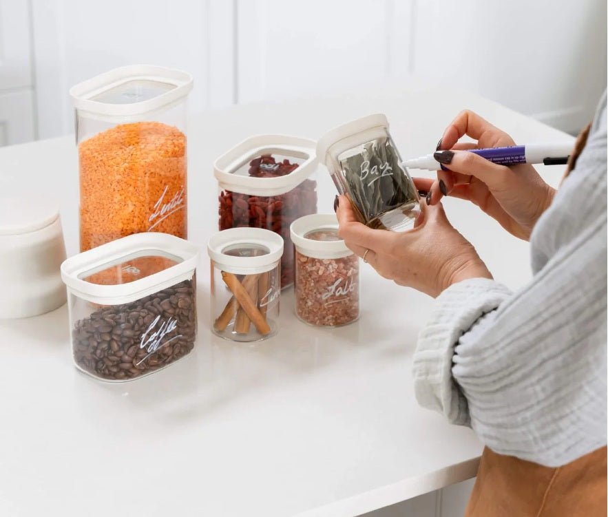Seed & Sprout Newrybar Spice Jars and pantry containers being labeled for kitchen organization.