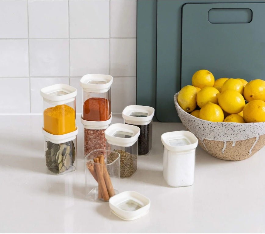 Seed & Sprout Newrybar Spice Jar Set displayed with pantry spices and a ceramic bowl of lemons.