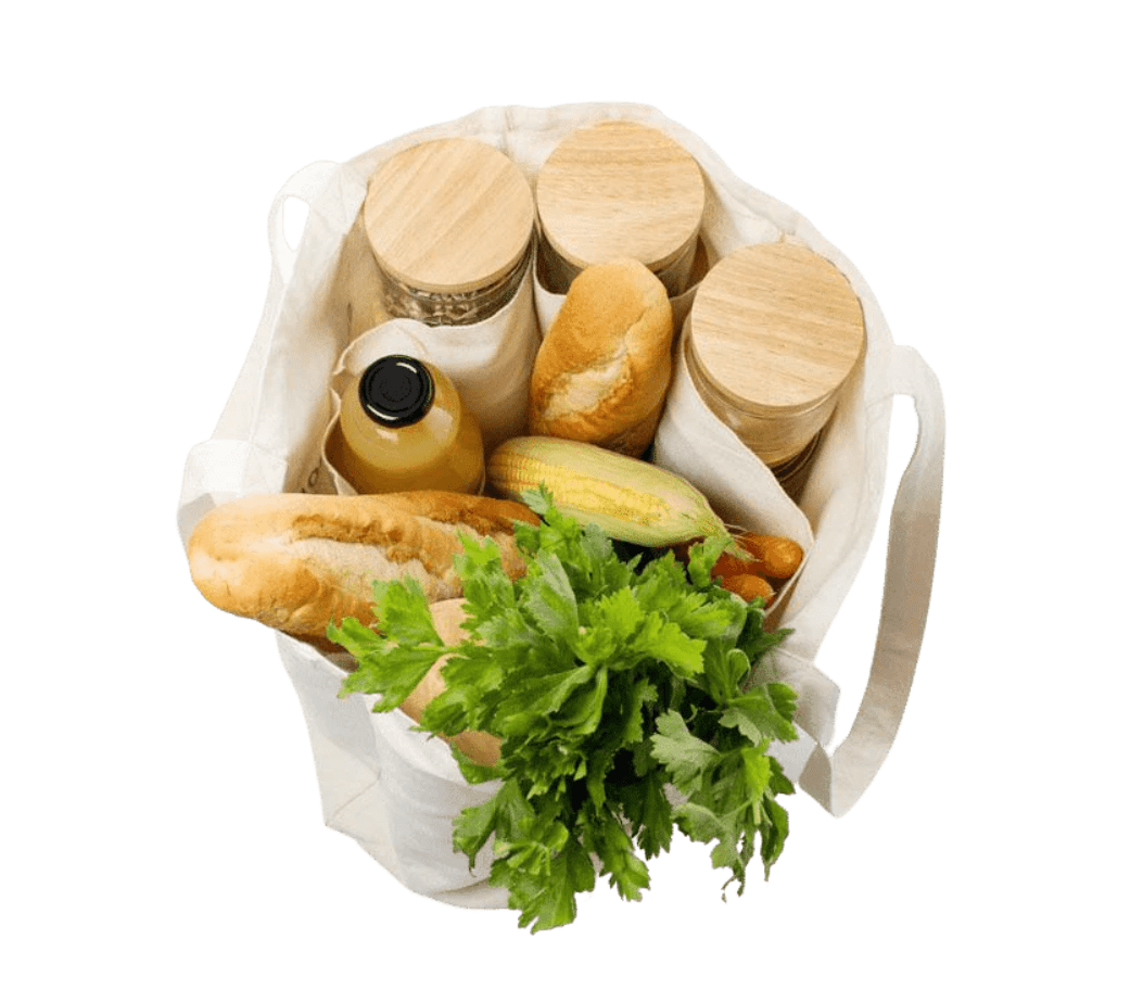 op-down studio shot of the Seed & Sprout organic canvas market tote packed with glass storage jars, fresh bread, corn, and leafy greens.
