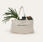 Seed & Sprout natural organic cotton tote bag filled with fresh spring onions and market produce.