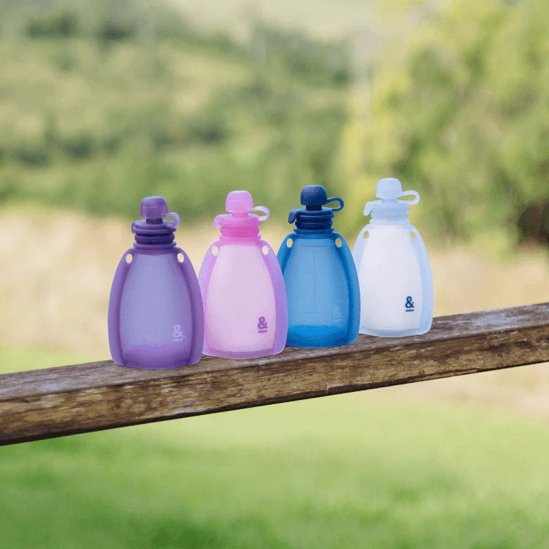 Seed & Sprout Reusable Yoghurt Pouches, Indigo and Plum, 2-pack, outdoors on a tree branch