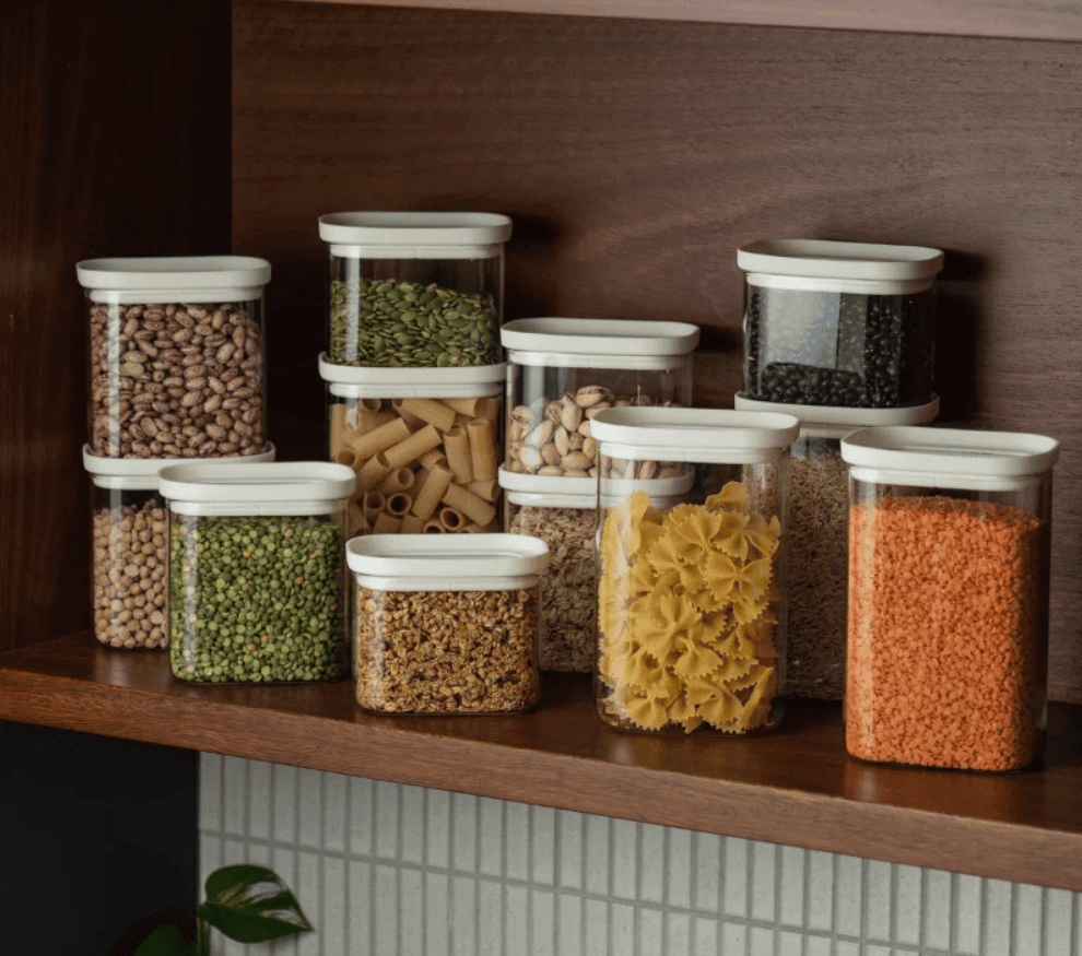 Seed & Sprout Tallow airtight pantry storage containers with oatmeal lids neatly organized and filled with dry goods on a shelf.