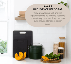 Seed & Sprout set of three Liquorice wood fibre chopping boards displayed in graduated sizes against a white tiled kitchen backsplash, alongside a green compost bin, sliced pumpkin, and pantry jars, featuring a superimposed 5-star customer review quote.