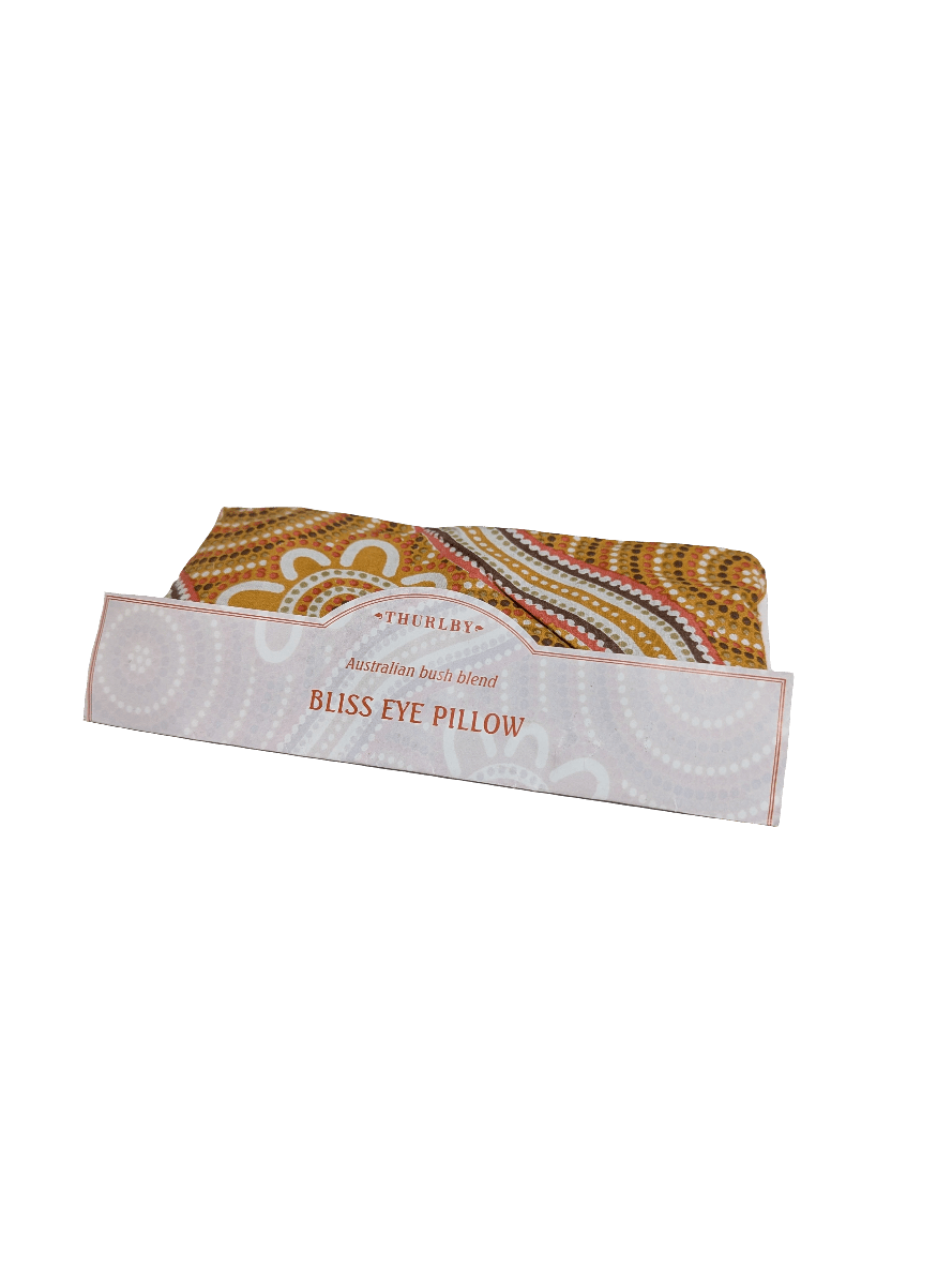 Thurlby Herb Farm Bliss Eye Pillow in an Australian Bush blend, featuring a warm yellow, orange, and brown dot-art pattern fabric wrapped in a branded paper band