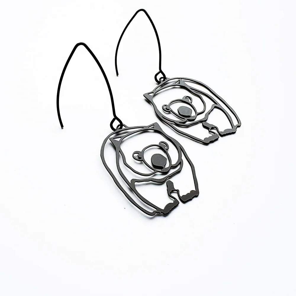 A pair of dark metallic cutout DENZ Wombat, shown on a plain white background.