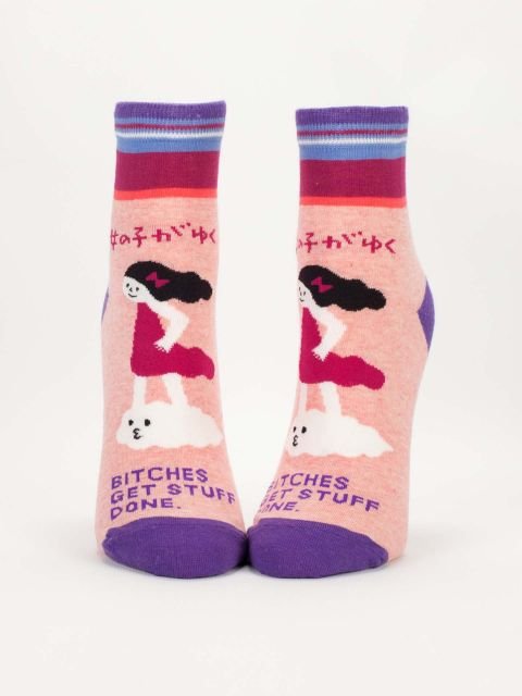 A pair of pink Blue Q ankle socks featuring a girl standing on a cloud illustration above purple text reading "BITCHES GET STUFF DONE."