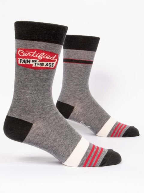A pair of heather grey Blue Q men's crew socks with black cuffs, athletic toe stripes, and a red patch reading "Certified PAIN IN THE ASS."