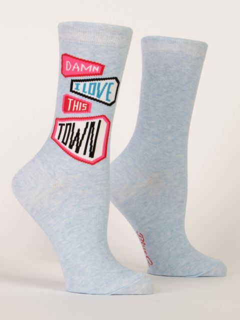 A pair of light heather blue Blue Q crew socks featuring graphic street sign badges reading "DAMN I LOVE THIS TOWN".