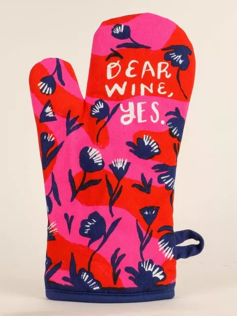 A bright pink and red floral Blue Q oven mitt with white text reading "DEAR WINE, YES." and a navy blue hanging loop.