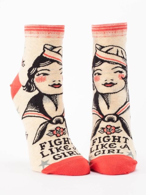 A pair of cream Blue Q ankle socks featuring a retro vintage sailor woman illustration above text reading "FIGHT LIKE A GIRL".