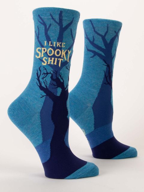 A pair of blue Blue Q women's crew socks featuring dark, bare spooky tree silhouettes and yellow text reading "I LIKE SPOOKY SHIT."