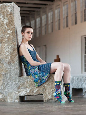 Blue Q Im A Delicate Fucking Flower Womens Crew Socks Model On Stone Bench Studio Photo.