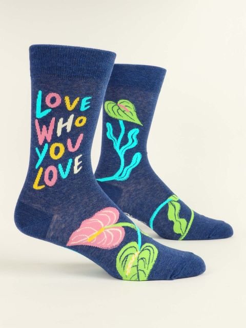 Pair of Blue Q men's navy blue crew socks featuring vibrant botanical graphics and colorful text reading "LOVE WHO YOU LOVE".