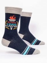 Pair of Blue Q men's dark navy crew socks featuring a flaming torch graphic and text reading "OLYMPIC LONG SLEEPER".
