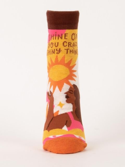 Front view of a single Blue Q women's ankle sock with a sun and woman graphic reading "SHINE ON YOU CRAZY SHINY THING."