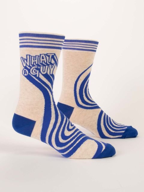Pair of Blue Q men's crew socks in cream and royal blue reading "WHAT A GUY" with graphic retro lines.