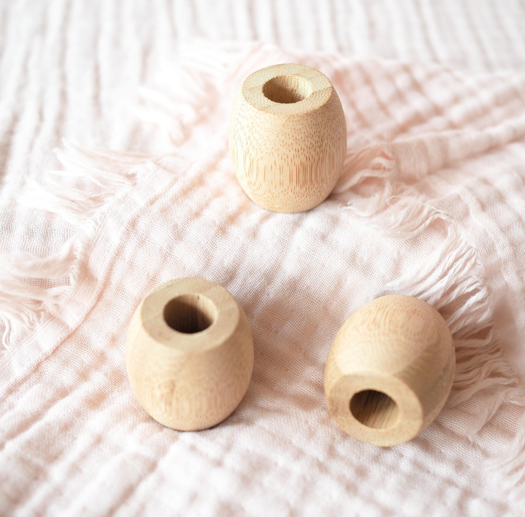 Brush It On bamboo toothbrush holders resting on a soft pink textured fabric blanket