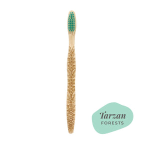 Brush It On Tarzan bamboo toothbrush featuring intricate forest leaf handle engravings and teal bristles