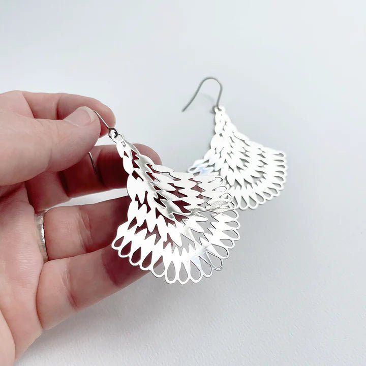 DENZ Essence dangles in silver, held by hand
