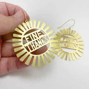 DENZ Fine thanks in gold earrings, held by hand