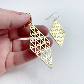 DENZ Kaleidoscope dangles in gold, held by hand