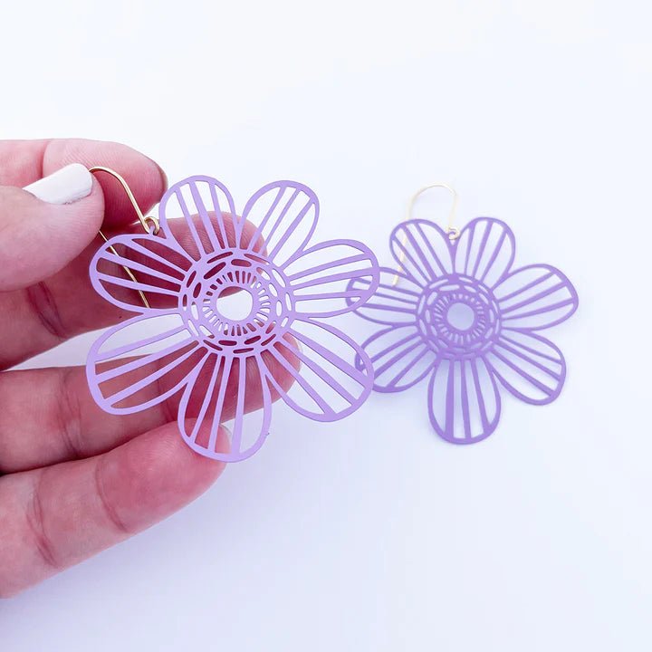 DENZ Midi Flowers in Purple earrings, held by hand