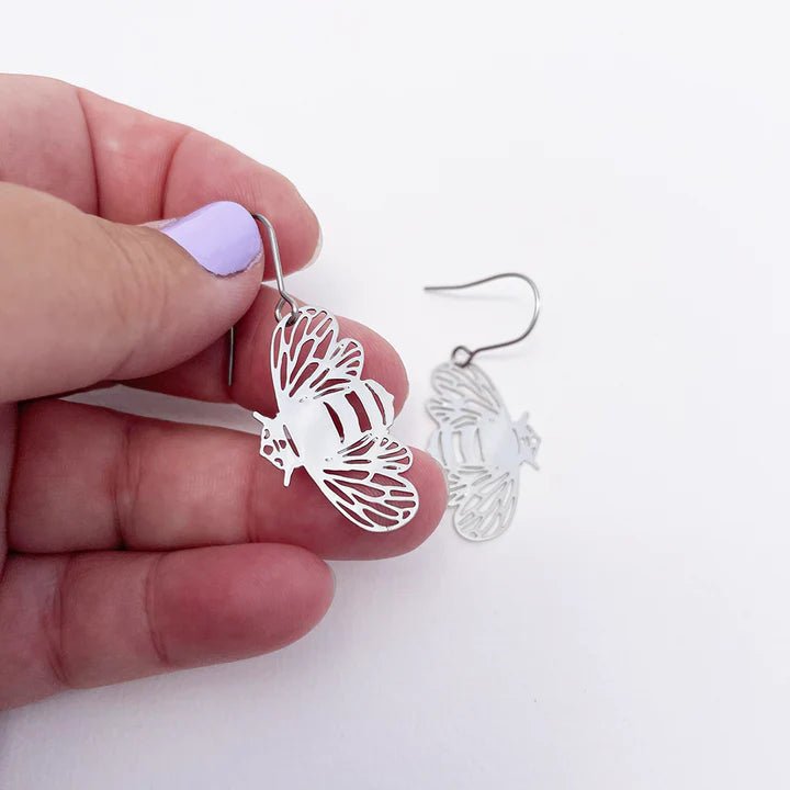 DENZ Mini Bee Dangles in Silver, held by hand