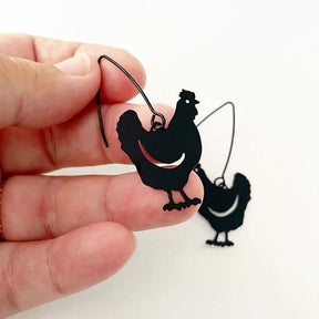 DENZ Mini Chicken dangles in black, held by hand