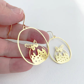 DENZ Mini Puddings in Gold earrings, held by hand