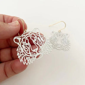 DENZ Mini Tigers in white earrings, held by hand