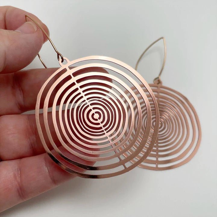 DENZ Orbit dangles (flat) in rose goldm held by hand
