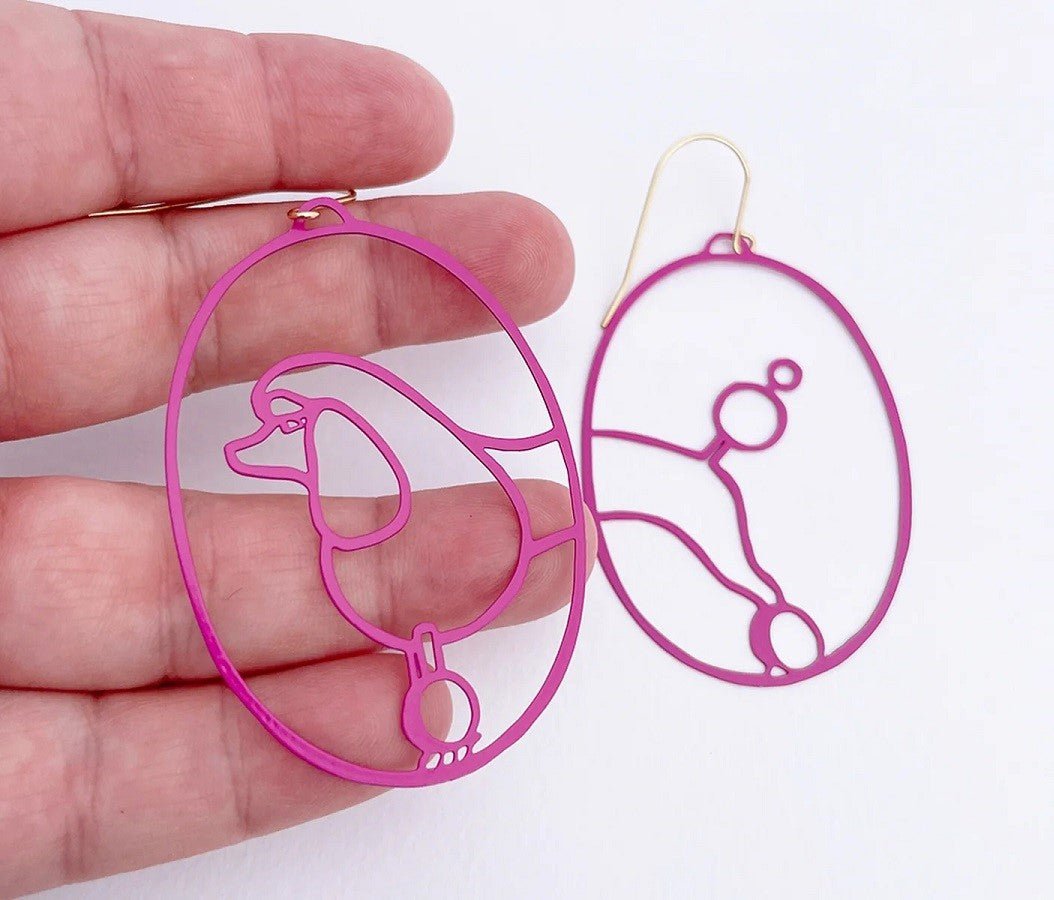 DENZ Poodles in Hot Pink earrings, held by hand
