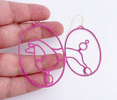 DENZ Poodles in Hot Pink earrings, held by hand