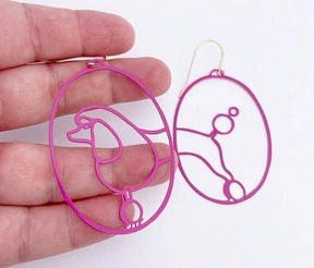DENZ Poodles in Hot Pink earrings, held by hand