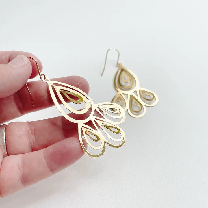 DENZ Reverie dangles in gold, held by hand
