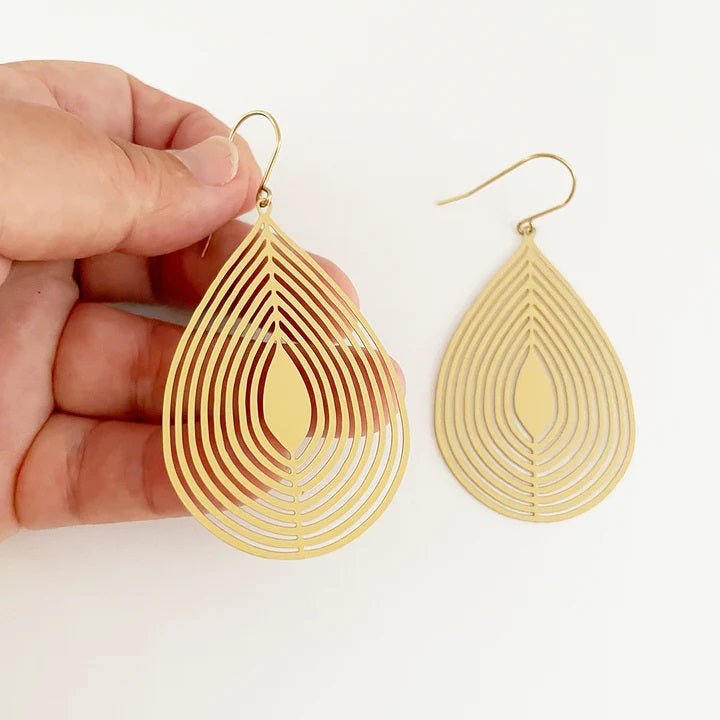DENZ Tear dangles 'flat' in gold, held by hand
