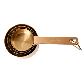 Seed & Sprout nesting metal measuring cup set in a warm bronze finish, securely stacked together on a removable storage ring.