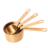 Seed & Sprout stainless steel measuring cup set of four in a warm bronze finish, featuring engraved volume measurements.
