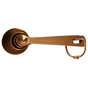 Seed & Sprout nesting metal measuring spoon set in a warm copper finish, neatly nested together and secured on a removable storage ring.